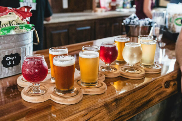 Trays of beer flights on polished wood bar top.