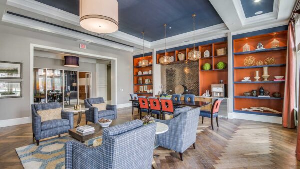 Clubroom with herringbone floor, plush seating, and colorful shelves with decor.